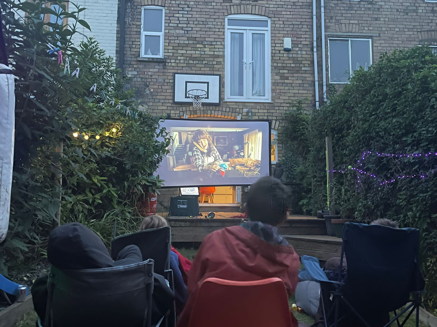 Image of friends gathered to watch Suitcase Cinema outdoor cinema kit
